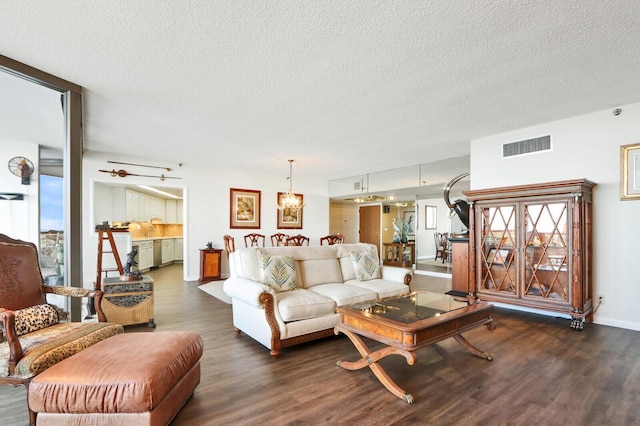 living room with dark hardwood / wood-style floors, a textured ceiling, and a wealth of natural light