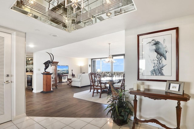 dining space with wood-type flooring, an inviting chandelier, and beverage cooler