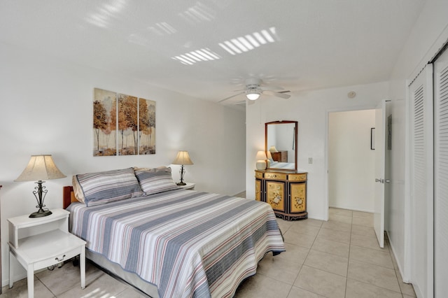 tiled bedroom with ceiling fan and a closet