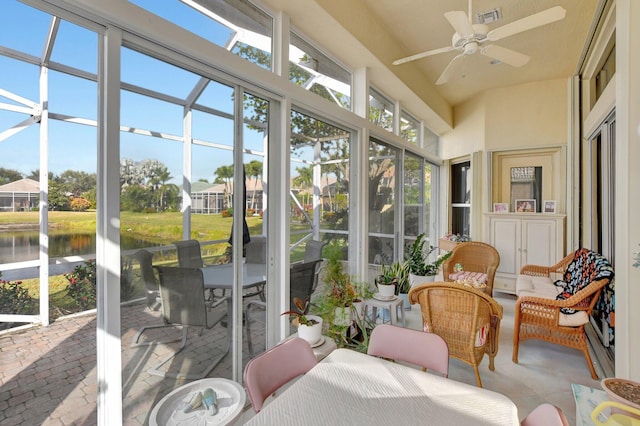 sunroom / solarium with ceiling fan and a water view