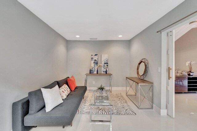 living room with beam ceiling, a barn door, and high vaulted ceiling