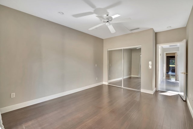 unfurnished bedroom with a closet, ceiling fan, and dark hardwood / wood-style flooring