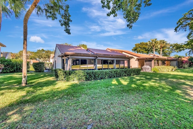 rear view of house featuring a lawn