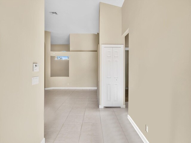 unfurnished living room with light tile patterned floors, lofted ceiling, and a notable chandelier