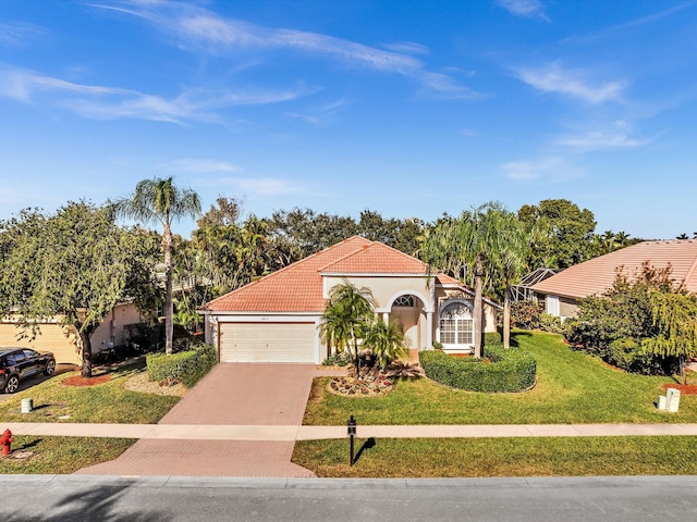 mediterranean / spanish-style home featuring a garage and a front lawn