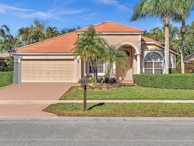 mediterranean / spanish-style house featuring a front yard and a garage