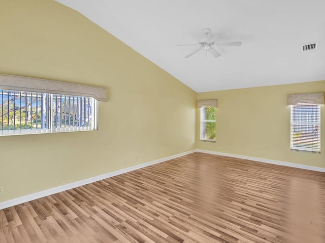 empty room with plenty of natural light, light hardwood / wood-style floors, lofted ceiling, and ceiling fan