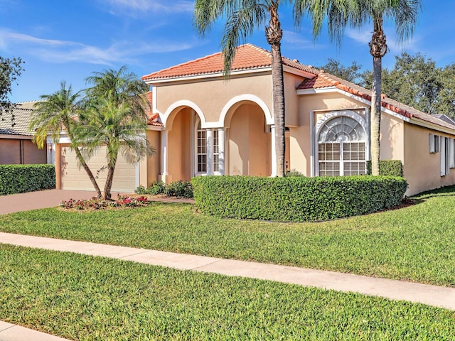 mediterranean / spanish-style home with a front lawn and a garage