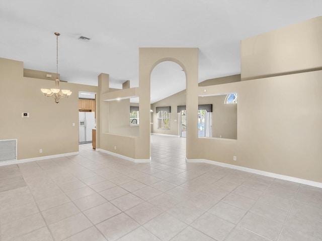 spare room featuring light tile patterned flooring, a chandelier, and vaulted ceiling