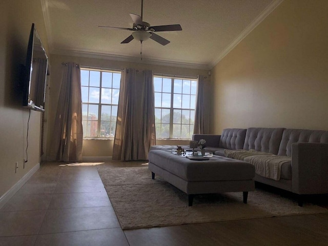 living room with lofted ceiling, dark tile patterned floors, ceiling fan, and crown molding