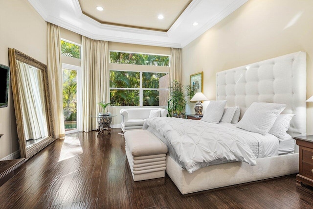 bedroom with a tray ceiling, a towering ceiling, dark wood-type flooring, and ornamental molding