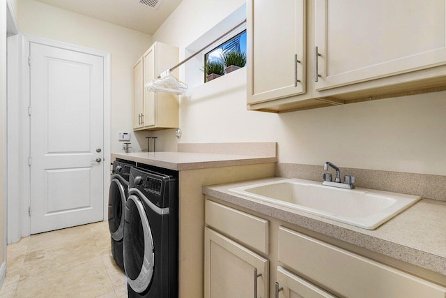 clothes washing area with cabinets, light tile patterned floors, washing machine and dryer, and sink