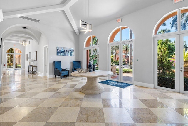 entryway with beamed ceiling, high vaulted ceiling, and french doors