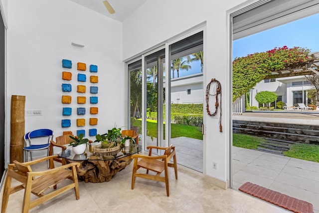 doorway featuring a towering ceiling and ceiling fan