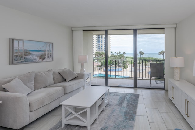 tiled living room with a water view and a wall of windows