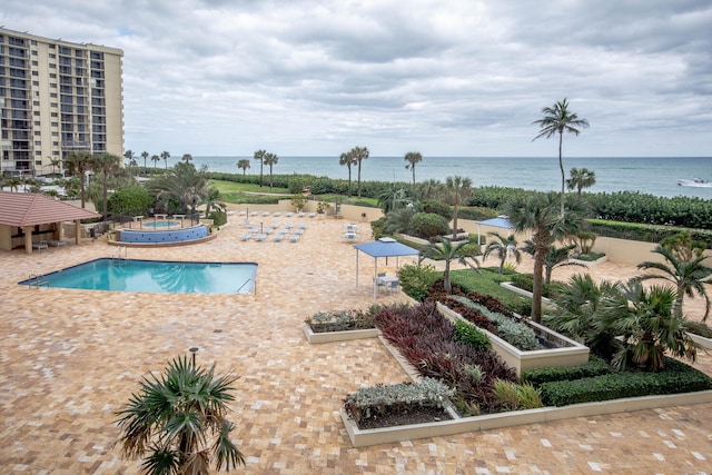 view of swimming pool with a water view and a patio