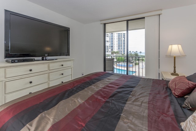 bedroom with access to exterior and a wall of windows