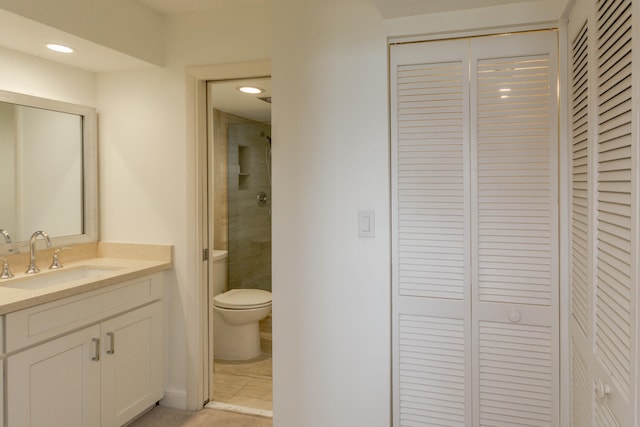 bathroom featuring tile patterned flooring, vanity, and toilet