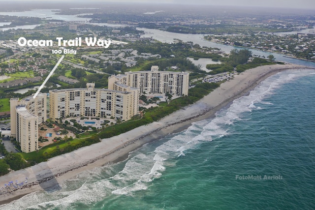 drone / aerial view with a water view and a beach view