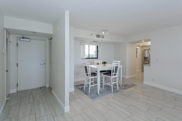 unfurnished dining area featuring a textured ceiling