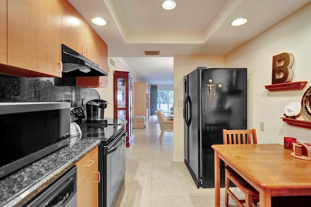 kitchen with black appliances, a raised ceiling, light tile patterned floors, and backsplash