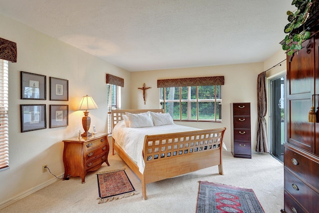 bedroom with light colored carpet and a textured ceiling