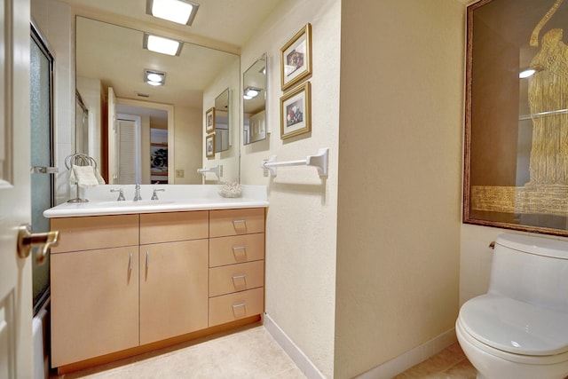 bathroom featuring tile patterned flooring, vanity, and toilet