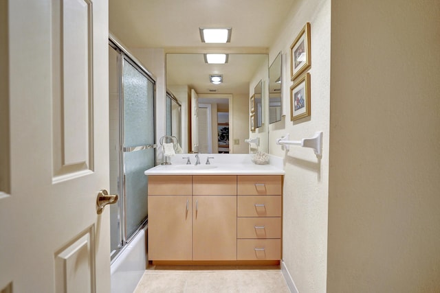 bathroom featuring tile patterned flooring, vanity, and shower / bath combination with glass door