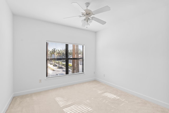 carpeted spare room featuring ceiling fan