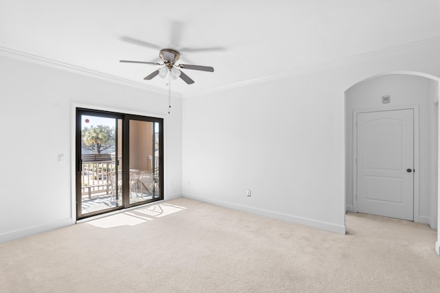 spare room featuring light carpet, ceiling fan, and crown molding