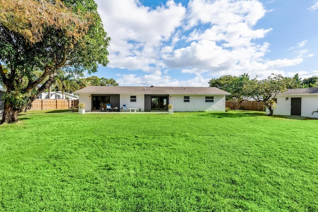 rear view of house featuring a patio and a lawn