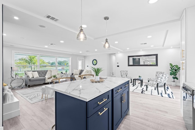 kitchen with blue cabinets, hanging light fixtures, light hardwood / wood-style flooring, a kitchen island, and light stone counters