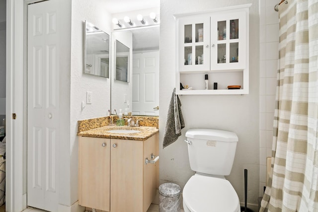 bathroom with curtained shower, vanity, and toilet