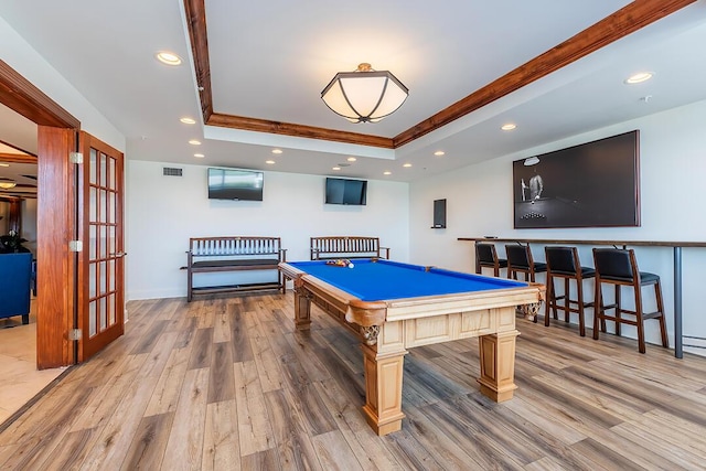 recreation room featuring light hardwood / wood-style floors, a raised ceiling, and billiards