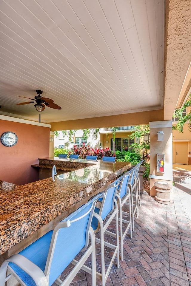 view of patio featuring ceiling fan and exterior bar