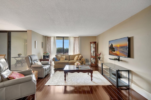 living room featuring a textured ceiling, dark hardwood / wood-style flooring, and a wall of windows