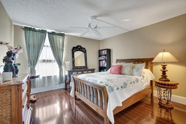 bedroom featuring a textured ceiling, ceiling fan, and dark wood-type flooring