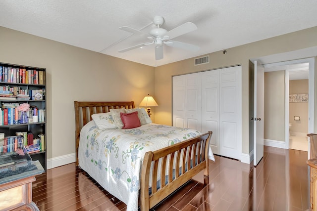 bedroom featuring a textured ceiling, ceiling fan, dark wood-type flooring, and a closet