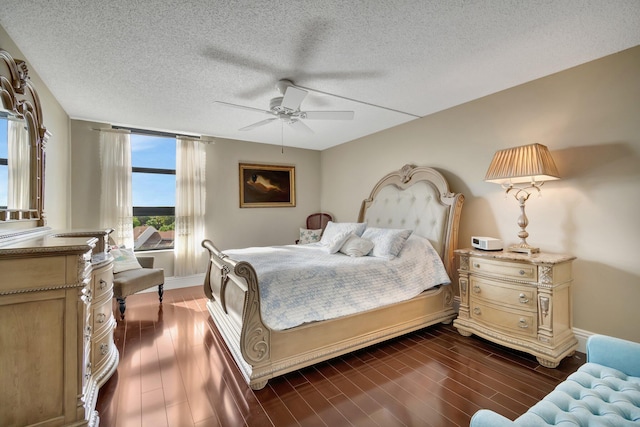 bedroom with a textured ceiling, dark hardwood / wood-style flooring, and ceiling fan