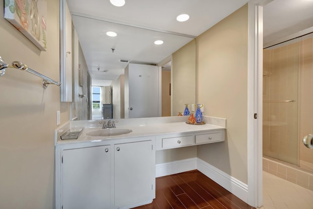 bathroom featuring hardwood / wood-style floors, vanity, and walk in shower