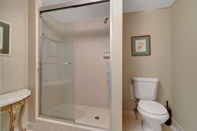 bathroom featuring tile patterned flooring, an enclosed shower, and toilet