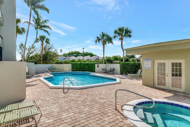 view of pool featuring an in ground hot tub, a patio, and french doors