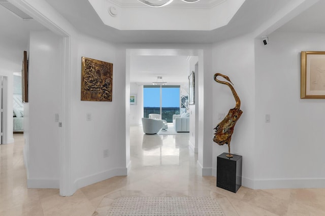 hall with crown molding, floor to ceiling windows, a raised ceiling, and light tile patterned floors