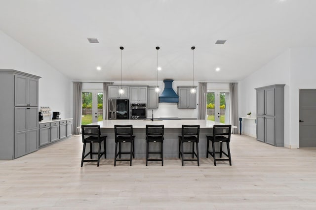 kitchen with gray cabinets, a wealth of natural light, and fridge with ice dispenser