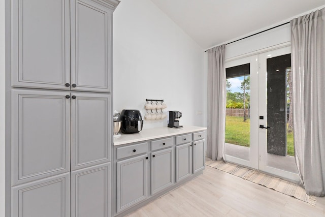 doorway with vaulted ceiling and light hardwood / wood-style flooring