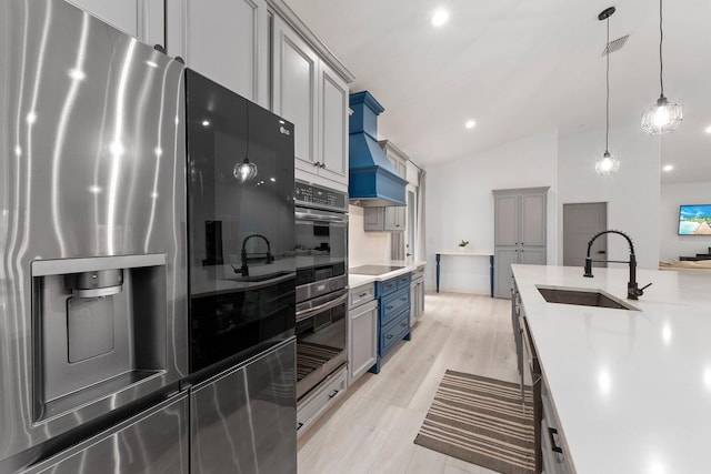 kitchen featuring light wood-type flooring, sink, refrigerator with ice dispenser, pendant lighting, and lofted ceiling