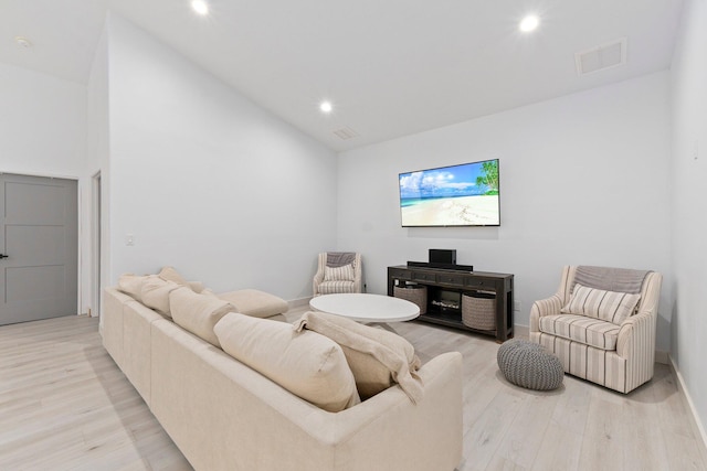 living room featuring light hardwood / wood-style floors and vaulted ceiling