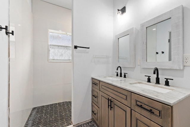 bathroom featuring a tile shower and vanity