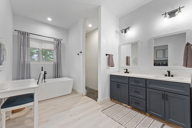 bathroom featuring a bath, wood-type flooring, and vanity