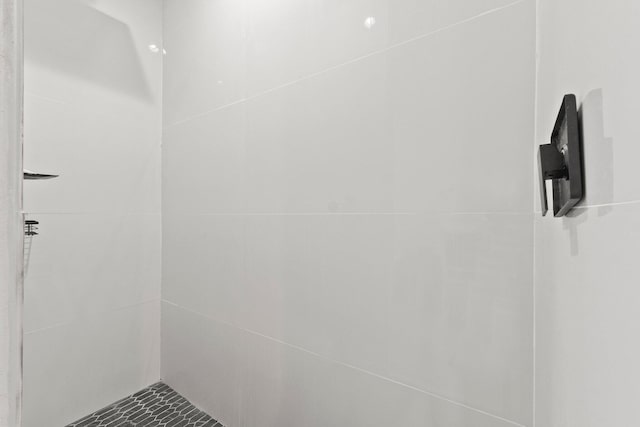 bathroom with tile patterned floors and tiled shower